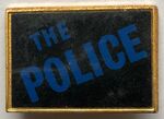 The Police square metal badge dark golden frame blue logo.jpg