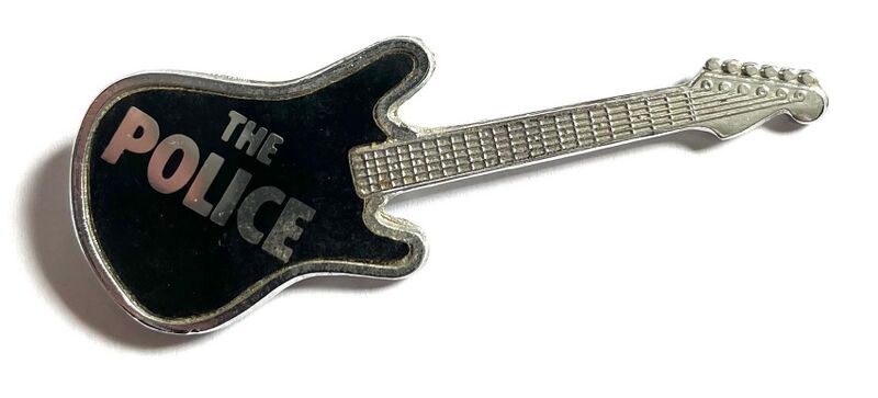 File:Guitar The Police black metal badge old logo.jpg